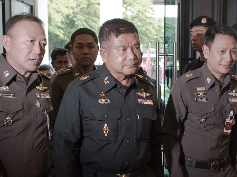 This file photo shows Thai Army Lieutenant General Manas Kongpan (centre) being surrounded by police officers. AFP file photo