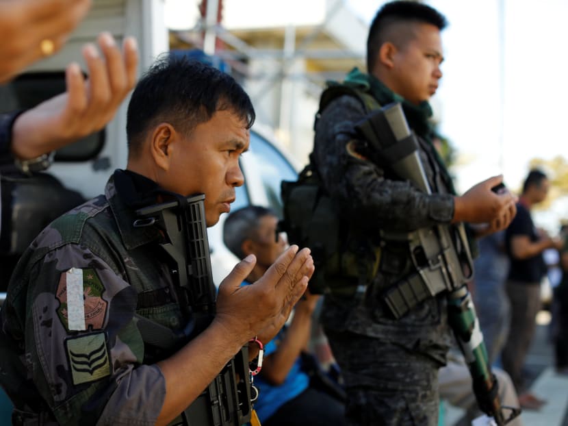 Philippines police pray outside a mosque in the city hall compound in as government forces continue their assault against insurgents from the Maute group, who have taken over large parts of Marawi City. Photo: Reuters