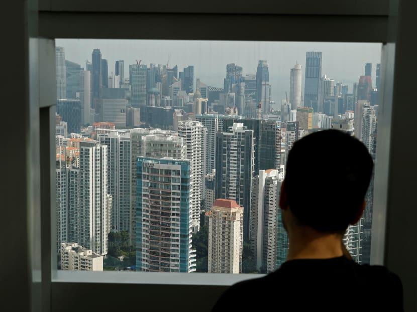 A man looking out at a cluster of private residential condominiums in Singapore.