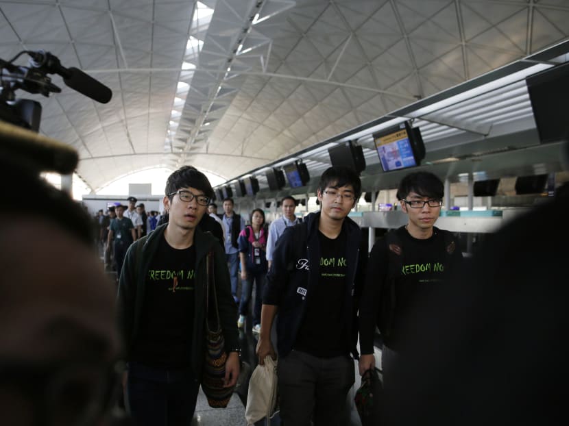 Hong Kong Federation of Students leader Alex Chow,center, committee members Nathan Law, left, and Eason Chung were denied permission to travel to Beijing at Hong Kong International Airport Saturday, Nov. 15, 2014. Three students who have led protests for greater democracy in Hong Kong were denied permission to travel to Beijing to meet with China's top officials. Photo: AP