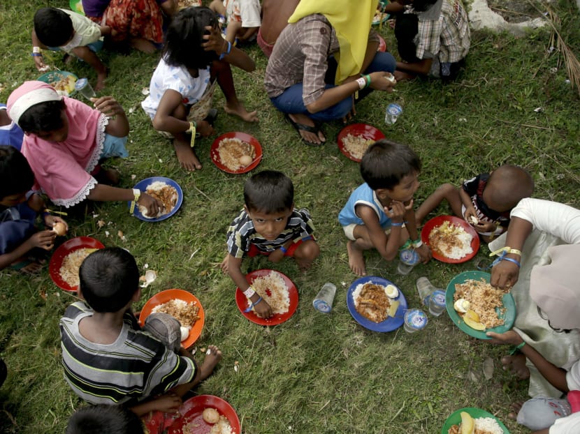 Ethnic Rohingya children receive their food at a temporary shelter in Bayeun, Aceh province, Indonesia, Saturday, May 23, 2015. Photo: AP