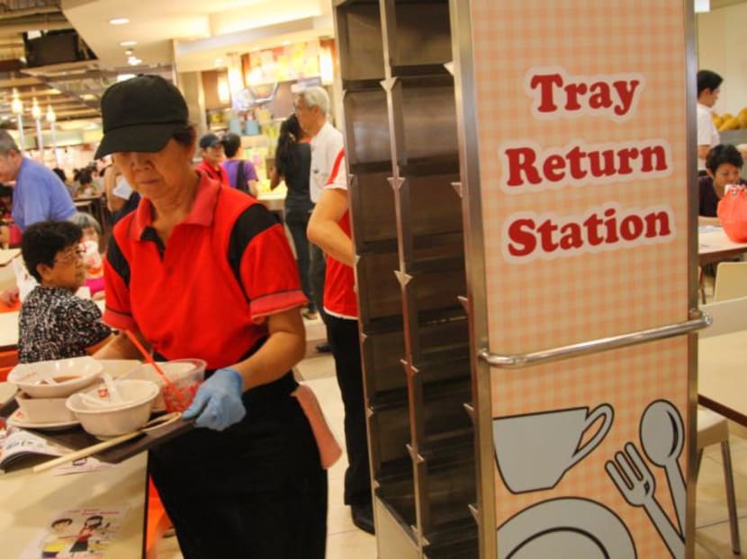 A cleaner clearing tables at Kou Fu food court at HDB hub where Tray Return Stations are set up shortly after launching National Environment Agency's (NEA) The Tray Return Partnership. TODAY file photo
