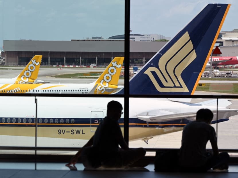 A Singapore Airlines plane is parked beside Scoots passenger planes on the terminal tarmac at Changi International Airport in Singapore on March 15, 2021.