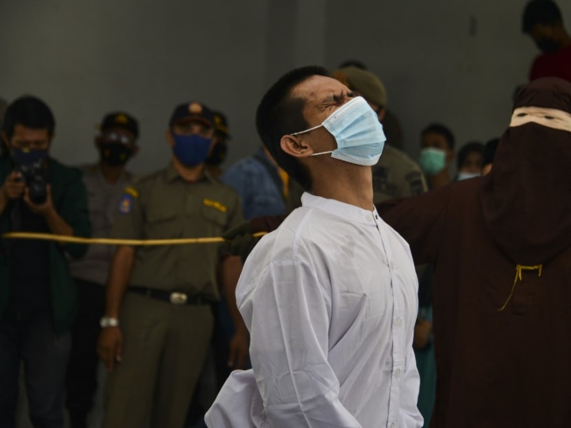 A man accused of having gay sex is publicly caned by a member of the Sharia police in Banda Aceh on Jan 28, 2021. Aceh is the only region in the world's biggest Muslim-majority nation that imposes Islamic law — known as Sharia — with those found guilty of breaches often publicly whipped with a rattan cane.