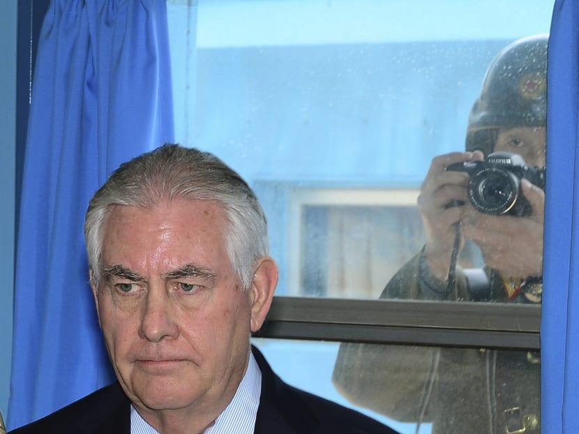 A North Korean soldier, right, tries to take a photograph through a window while U.S. Secretary of State Rex Tillerson visits at the UN Command Military Armistice Commission meeting room at the border village of Panmunjom, which has separated the two Koreas since the Korean War, South Korea, Friday, March 17, 2017. Photo: Yonhap via AP