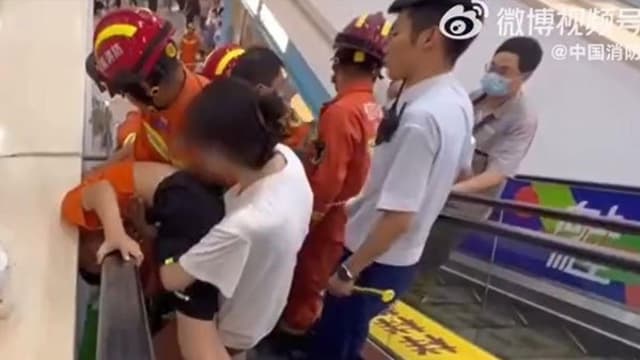手扶梯上探头中国男童头被卡  消防员拆墙解救