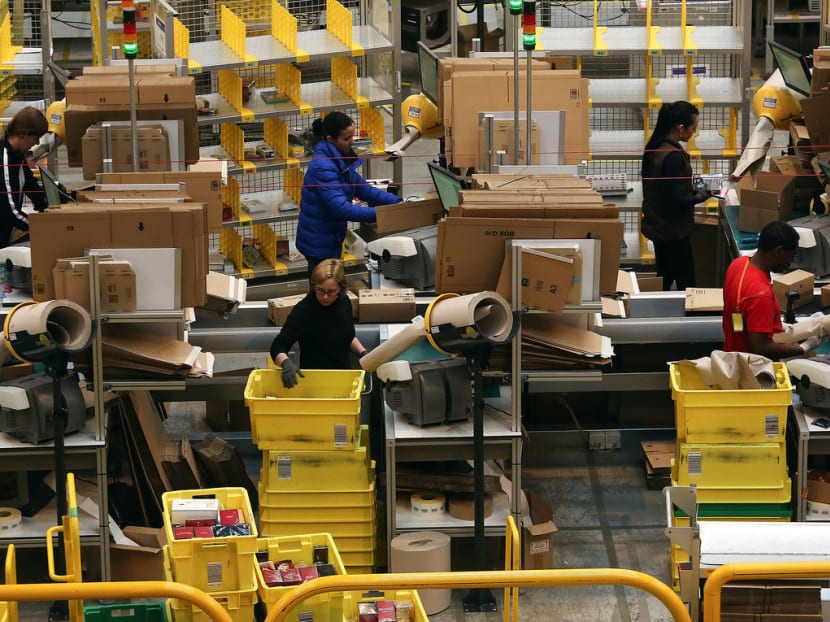 Employees process customer orders ahead of shipping at one of Amazon.com's fulfillment centers in Peterborough, UK. Photo: Bloomberg