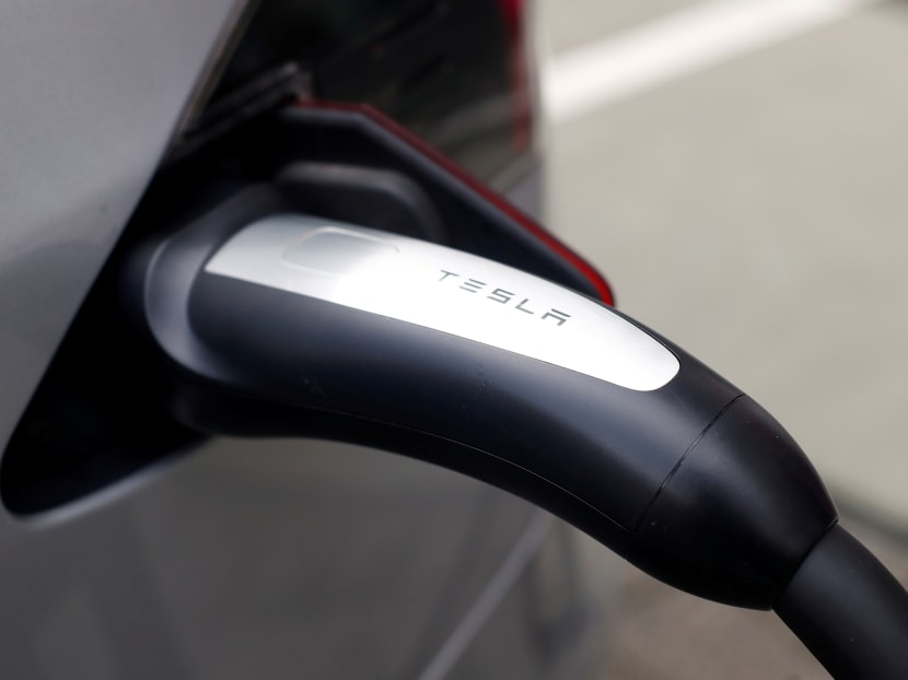 FILE PHOTO: A Tesla car is charged at Telekom's headquarters in Bonn. Photo: Reuters
