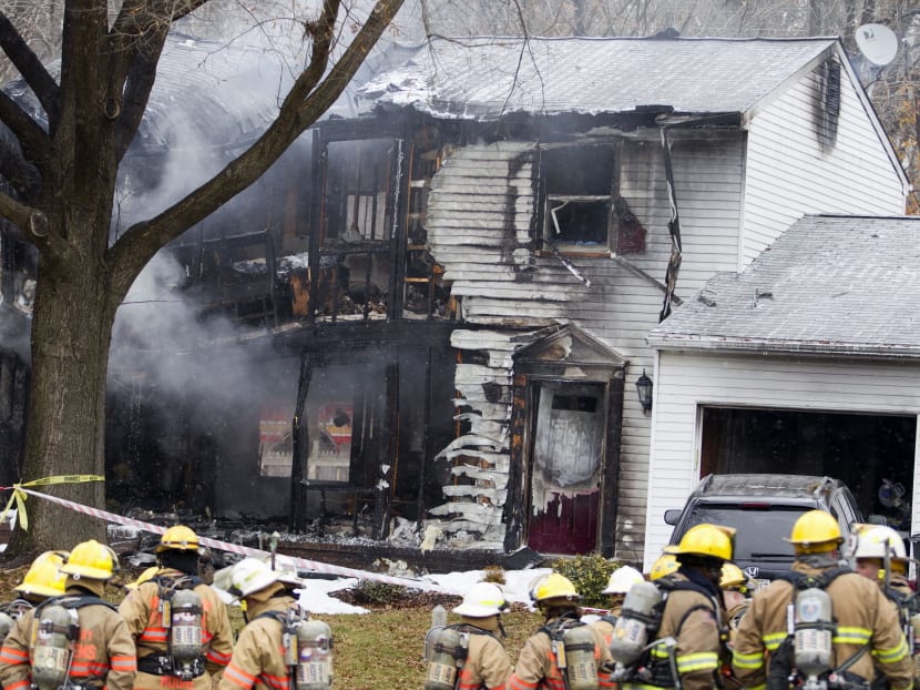 Firefighters stand outside a house in Gaithersbug, Maryland, Dec 8, 2014, where a small plane crashed.  Photo: AP