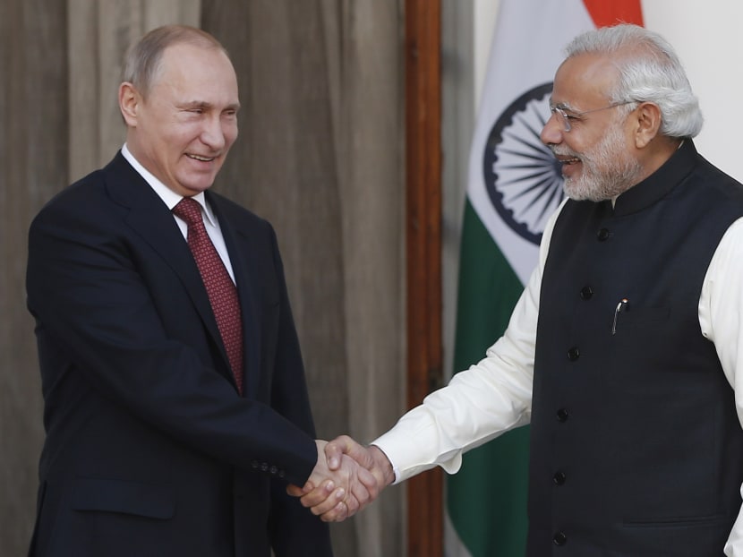Russian President Vladimir Putin (L) shakes hands with India's Prime Minister Narendra Modi during a photo opportunity ahead of their meeting at Hyderabad House in New Delhi on Dec 11, 2014. Photo: Reuters