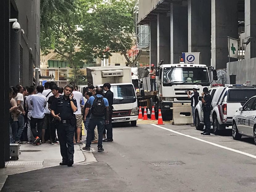 Police officers were seen talking to over 30 foreign workers at the site of the old Central Provident Fund building. The workers demanded answers over their unpaid salaries.