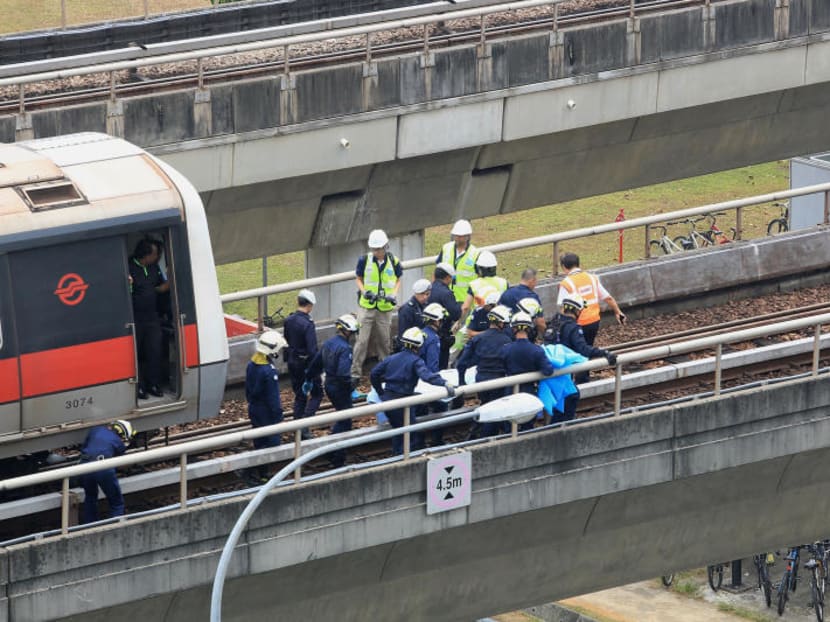 SCDF officers extricate a body on the scene of the train accident at Pasir Ris MRT station which left two SMRT staff dead. TODAY file photo