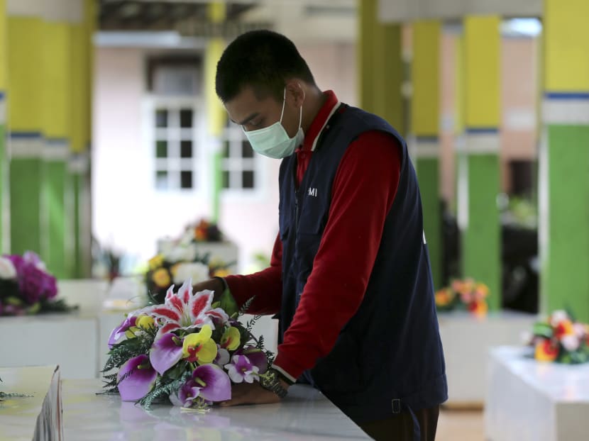 A member of The Indonesia Red cross prepares coffins for the victims of AirAsia Flight 8501 at the main hospital in Pangkalan Bun today. Photo: AP