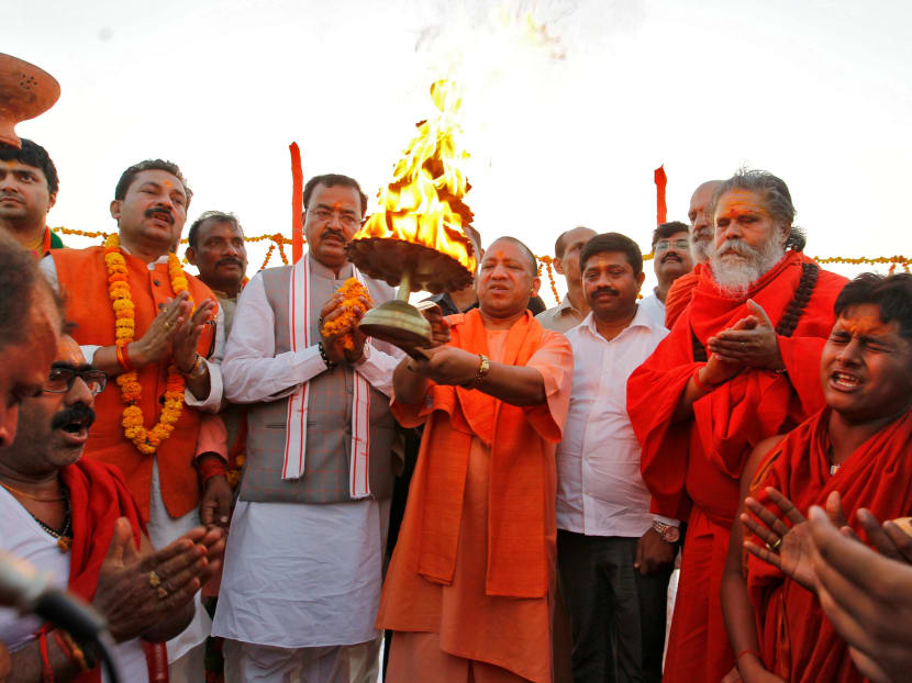 Mr Yogi Adityanath, Chief Minister of India's Uttar Pradesh state, holds a traditional lamp as he performs prayers. Violent outbreaks between Hindus and Muslims have become more common in some pockets of India including in Uttar Pradesh. Photo: Reuters