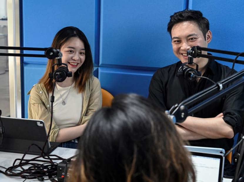 Hosts of Chinese podcast "The Weirdo" Meng Chang (right) and Xie Ruohan laughing during recording an episode in a studio in Beijing.