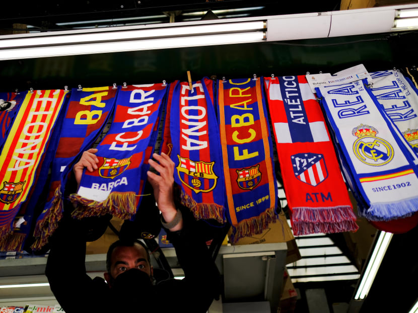 FC Barcelona, Atletico Madrid and Real Madrid scarves are displayed inside a store at Las Ramblas as twelve of Europe's top football clubs launch a breakaway Super League.