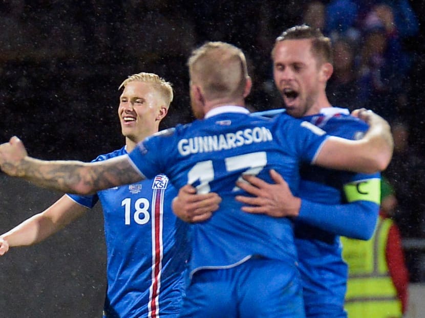 (Left to right): Iceland's Hordur Magnusson, Iceland's midfielder Aron Gunnarsson and Iceland's midfielder Gylfi Sigurdsson celebrate after the FIFA World Cup 2018 qualification football match between Iceland and Kosovo in Reykjavik, Iceland on October 9, 2017. Iceland qualified for the FIFA World Cup 2018 as smallest country ever after beating Kosovo 2-0 at home in Reykjavik. Photo: AFP