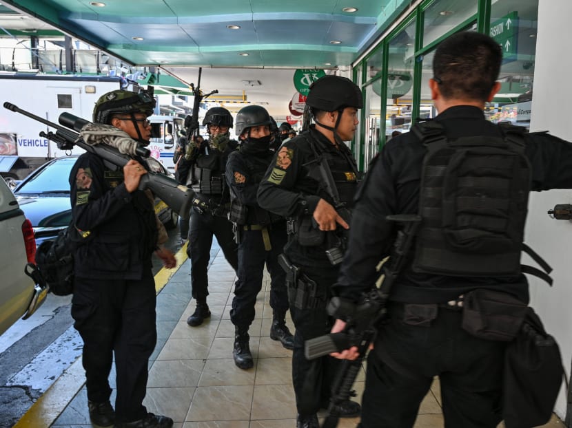 Members of a police SWAT team take positions outside one of the entrances to a mall after a hostage situation was reported in suburban Manila on March 2, 2020. Heavily armed police were deployed at the mall in the Philippine capital Manila after reports that a disgruntled employee was holding a group of people hostage, an AFP journalist saw.