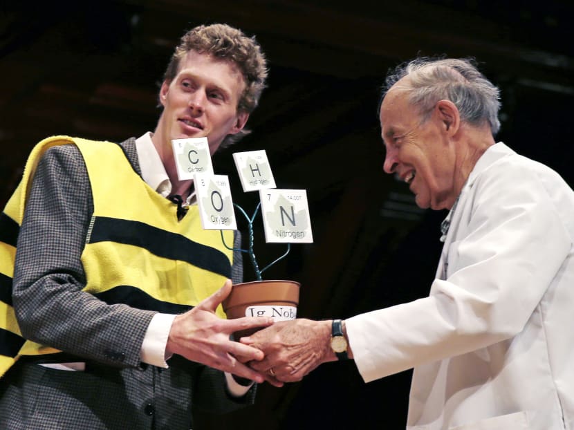Mr Michael Smith, left, accepts his trophy from Dudley Herschbach, the 1986 Nobel Laureate in Chemistry, while being honored during a performance at the Ig Nobel Prize ceremony at Harvard University, in Cambridge, Massachusetts, Sept 17, 2015. Photo: AP