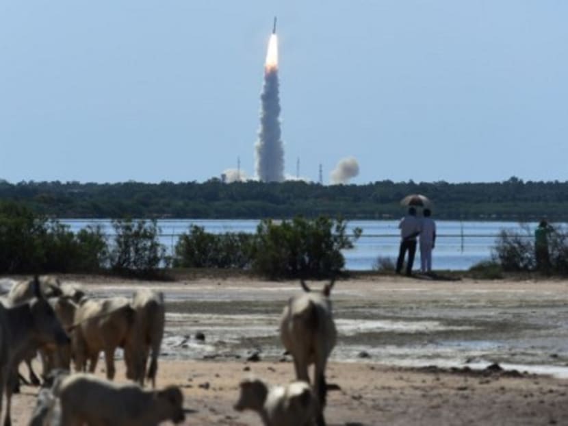 Bystanders watch as the Indian Space Research Organisation's satellite CARTOSAT-2, along with satellites from the US, Canada, Germany and Indonesia on board the Polar Satellite Launch Vehicle, is launched from Sriharikota in the southern state of Andhra Pradesh on June 22, 2016.