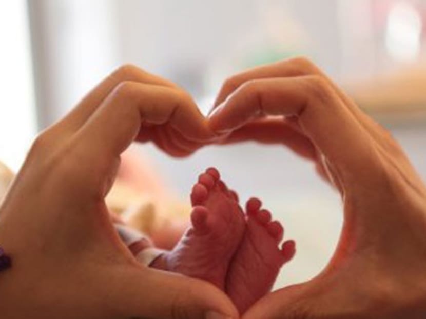 A photo of Wang and his wife creating a heart sign with their hands around their child's little feet, which accompanied the singer's micro blog post. Photo: Channel NewsAsia