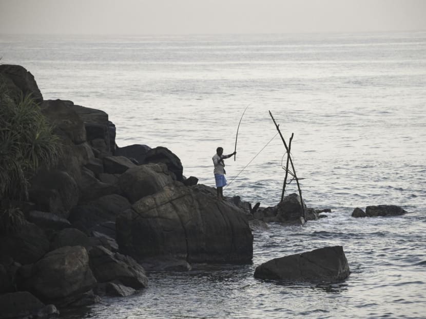 In this picture taken on December 30, 2021, a man fishes at the Indian ocean in Ahangama