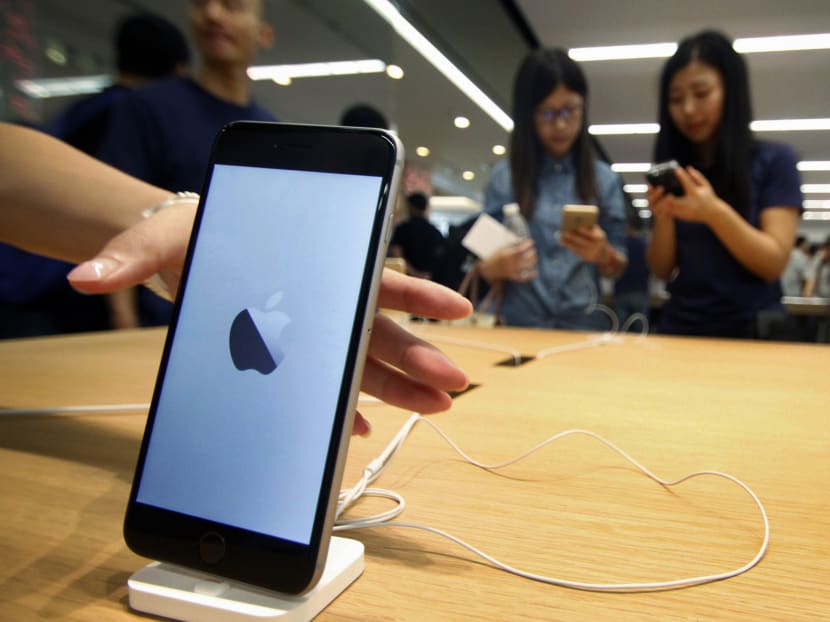 In this Sept 19, 2015 photo, Chinese women try iPhone sets at a newly-opened Apple Store in Nanjing in east China's Jiangsu province. Photo: AP