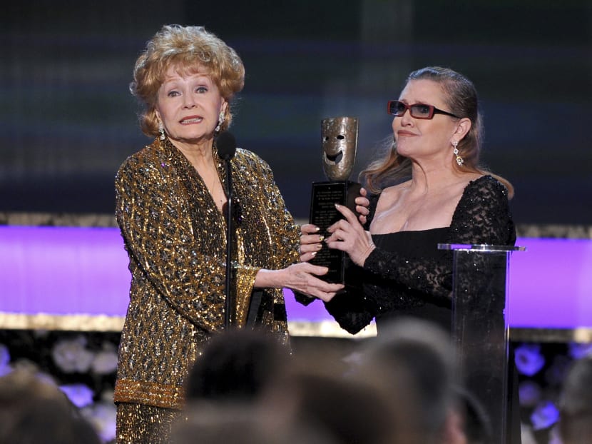 File photo of Carrie Fisher (right), presenting to her mother, Debbie Reynolds with the Screen Actors Guild life achievement award at the 21st annual Screen Actors Guild Awards in Los Angeles on Jan 25, 2015. Photo: Invision via AP