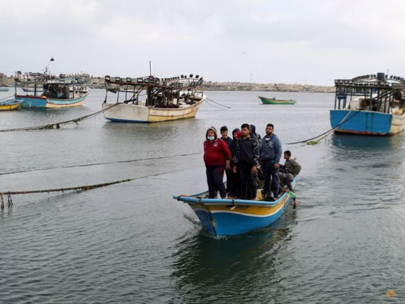 FILE PHOTO: Palestinian fishermen riding on a boat make their way back after Israel restricted Palestinian fishing zone in response to Palestinian rockets, at the seaport of Gaza City April 26, 2021. REUTERS/Mohammed Salem/File Photo