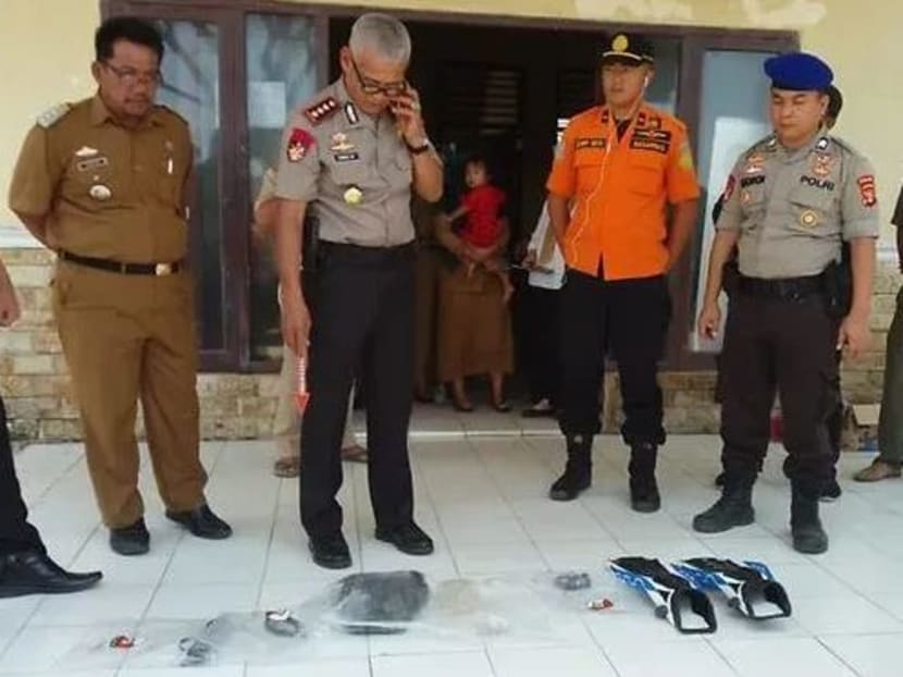 Basarnas officers and local police examining the diving equipment on the body found off Sumatra's Lampung province.