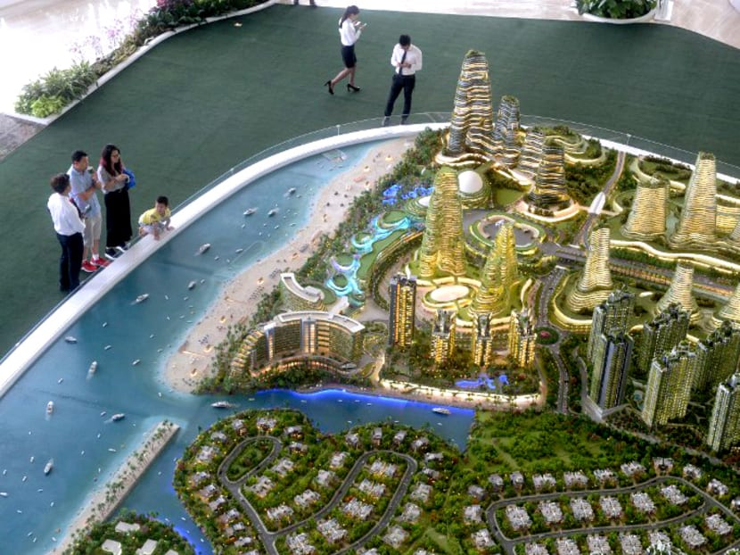 Visitors view the scale model of development at Forest-City on one of the man-made islands on the Malaysian side of the Straits of Johor.   A planned multi-billion-dollar new city near Singapore is attracting interest from investors with promises of luxury living but there are questions over its future owing to China's economic woes and warnings of environmental catastrophe. Photo: AFP