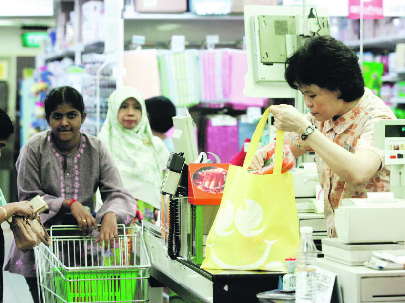 TODAY file photo of an NTUC fairprice checkout staff packing groceries into a reusable bag for a customer on Bring Your Own Bag Day (BYOBD) at it's Toa Payoh outlet.