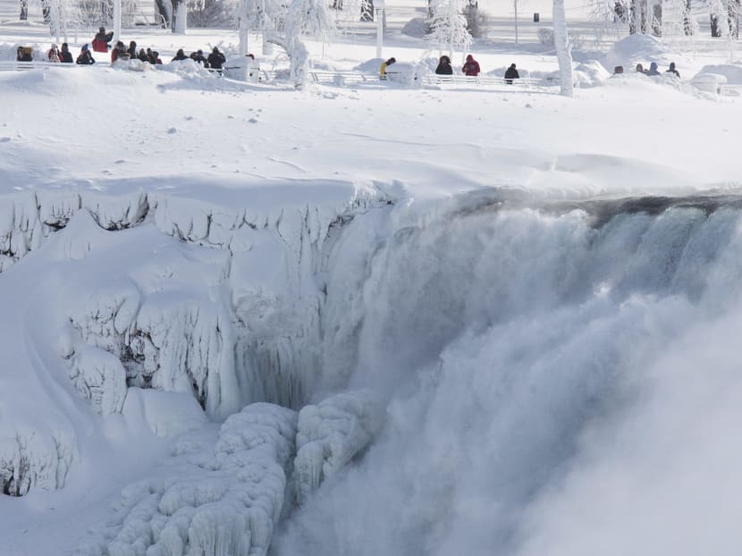 Niagara Falls State Park visitors look over masses of ice formed around the American Falls, photographed from across the Niagara River in Niagara Falls, Ontario, Canada, Thursday, Feb. 19, 2015. Photo: AP