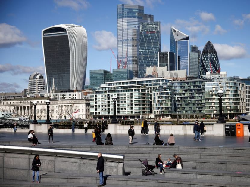 The City of London financial district can be seen as people walk along the south side of the River Thames, amid the coronavirus disease (Covid-19) outbreak in London, Britain, Mar 19, 2021. 
