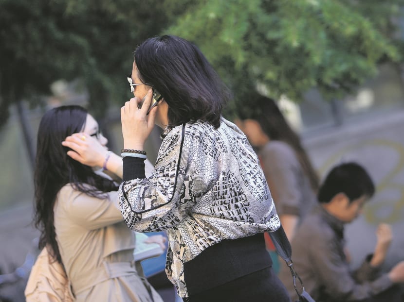 People talking on cell phones while walking. Bloomberg file photo