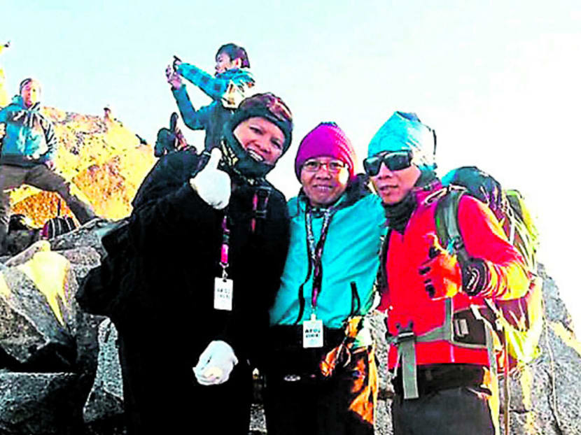 Robbi Sapinggi (right) with two climbers on Mount Kinabalu in early April. He died soon after the rescue team found him. Photo: Malay Mail Online