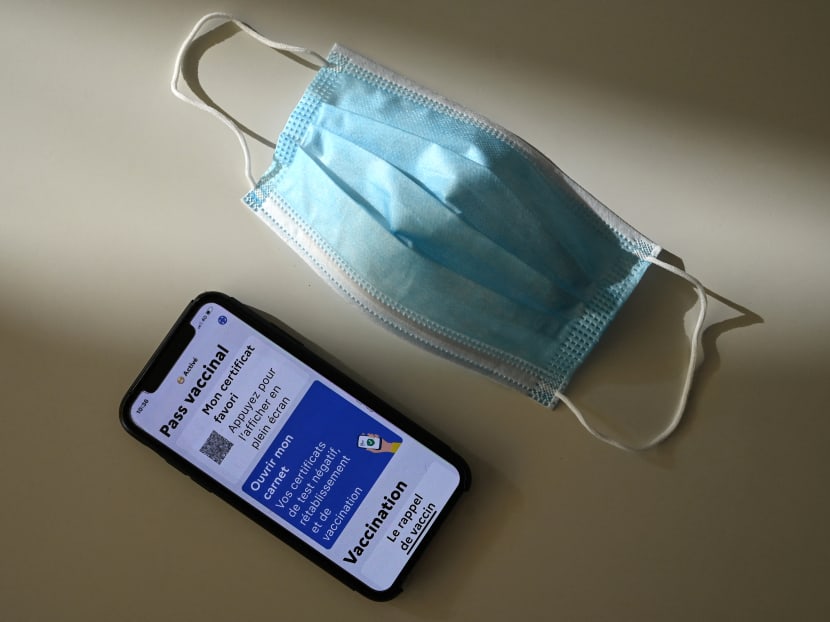 A face mask and a health pass on a mobile phone screen connected to a Covid-19 tracing application in France, which allows people vaccinated against Covid-19 to access bars, restaurants or regional transports.