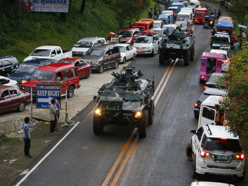 Armored personnel carriers making their way through a queue of vehicles with fleeing residents as  militants lay siege to Marawi city in southern Philippines. Photo: AP