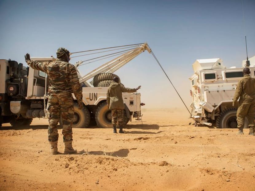 FILE PHOTO: Members of the MINUSMA Guinean contingent pull their stranded escort vehicle during a logistic convoy from Gao to Kidal, Mali February 17, 2017. Each month MINUSMA organizes logistic convoys involving hundreds of civilians and military vehicles to supply remote UN bases in northern Mali. Picture taken February 17, 2017. MINUSMA/Sylvain Liechti handout via REUTERS   