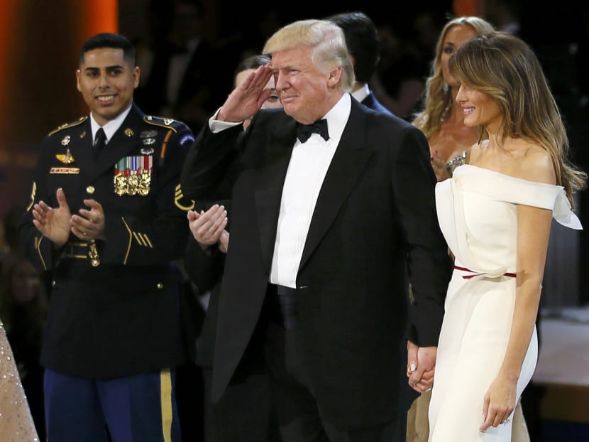 US President Donald Trump salutes as he stands his wife first lady Melania Trump at the "Salute to Our Armed Forces" inaugural ball during inauguration festivities in Washington, DC Jan 20, 2016. Photo: Reuters