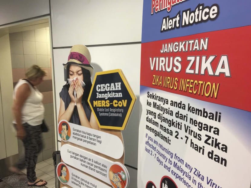 A traveller walks past travel advisory on the Zika virus infection in Kuala Lumpur International Airport (KLIA) in Sepang, Malaysia, Sunday, Aug. 28, 2016. Photo: AP