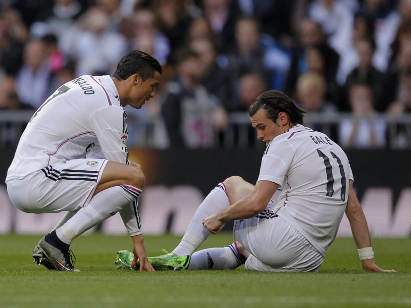 Real Madrid's Gareth Bale, right, gestures to teammate Cristiano Ronaldo after he got injured during a Spanish La Liga soccer match between Real Madrid and Malaga at the Santiago Bernabeu stadium in Madrid, Spain, Saturday, April 18, 2015. Photo: AP