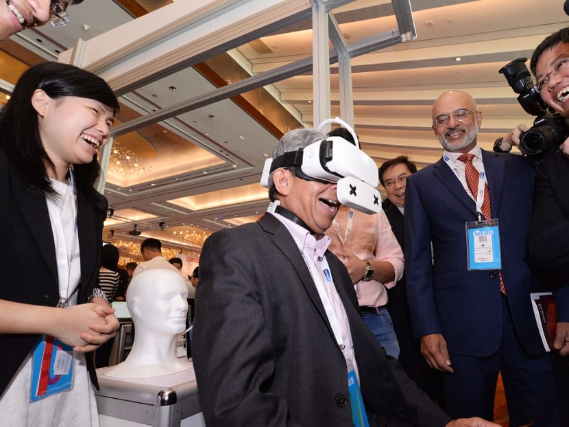 Dr Yaacob Ibrahim (centre), minister for Communications and Information, trying out the Ambiotherm virtual reality headset accessory at the innovfest unbound Singapore 2017, on May 3, 2017. Photo: Robin Choo/TODAY Dr Yaacob Ibrahim (centre), minister for Communications and Information, trying out the Ambiotherm virtual reality headset accessory at the innovfest unbound Singapore 2017, on May 3, 2017. Photo: Robin Choo/TODAY