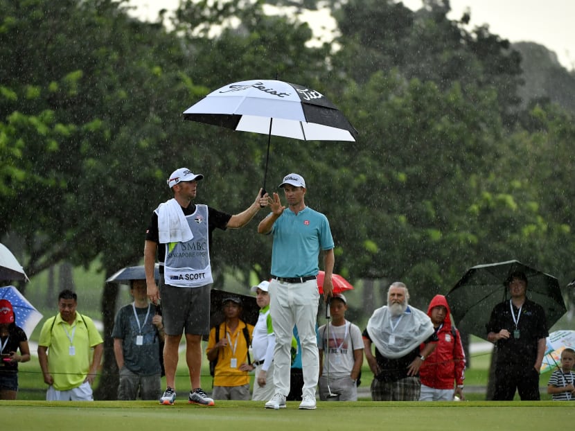 Adam Scott of Australia sheltering from the rain during the third round of the Singapore Open golf tournament taking place in Singapore from January 19 to 22. Photo: Lagardere Sports via AFP