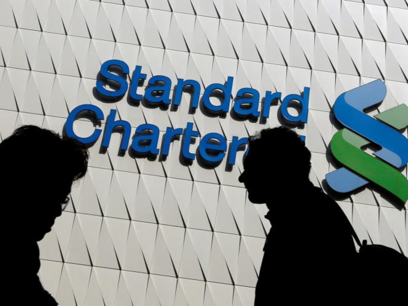 Passersby walk in front of the main branch of Standard Chartered in Hong Kong, Jan 8, 2015. Photo: Reuters