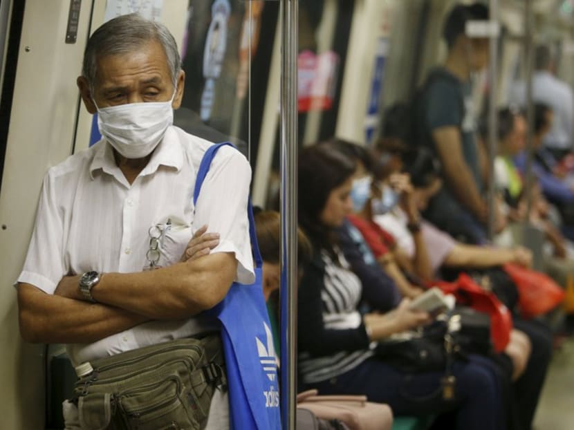 People wearing masks take the train during the morning commute in Singapore September 25, 2015. Photo: Reuters