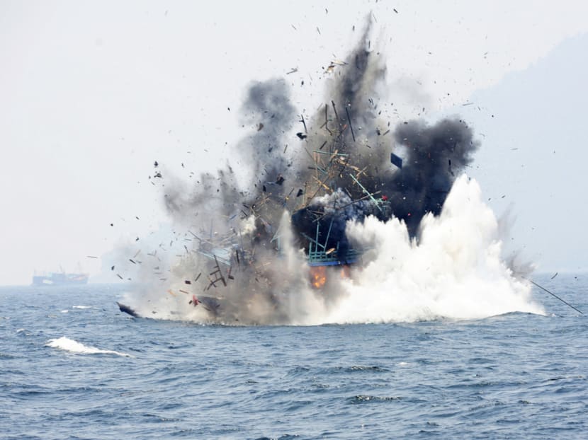 A foreign fishing boat confiscated for illegal fishing is blown up by the Indonesian Navy off of Lemukutan Island, West Kalimantan, on Aug 18. Photo: REUTERS