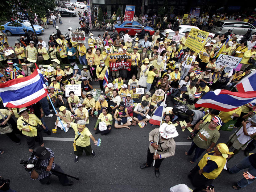 Yellow-shirted Thai protesters of the nationalist People's Alliance for Democracy (PAD) wave national flags during a demonstration in Bangkok in June 2011. The old yellow shirts of the PAD later started to don other colours before morphing into the 'salim'.