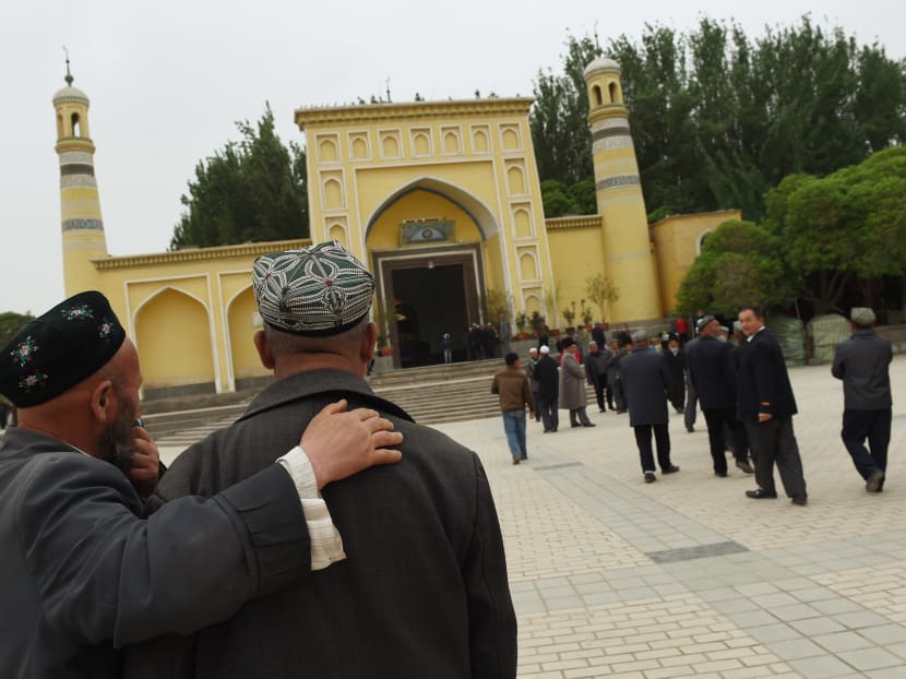 Uighur men making their way to the Id Kah mosque for afternoon prayers in Kashgar, in China's western Xinjiang region.