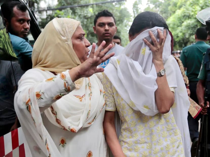 A relative tries to console Semin Rahman, covering face, whose son is missing after militants took hostages in a restaurant popular with foreigners in Dhaka, Bangladesh, on July 2, 2016. Photo: AP